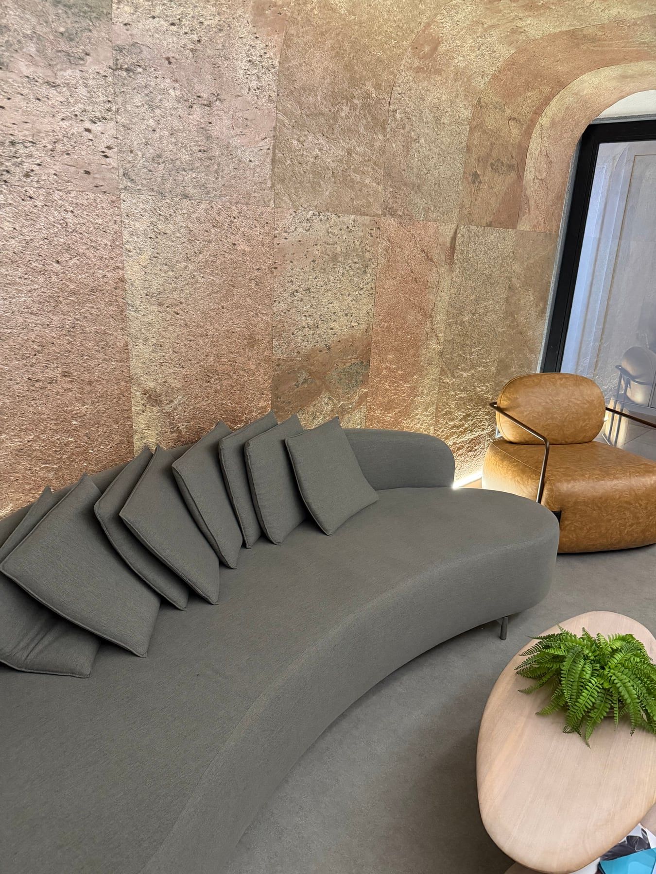 Detalhe da parede de pedra e da poltrona de couro na recepção
