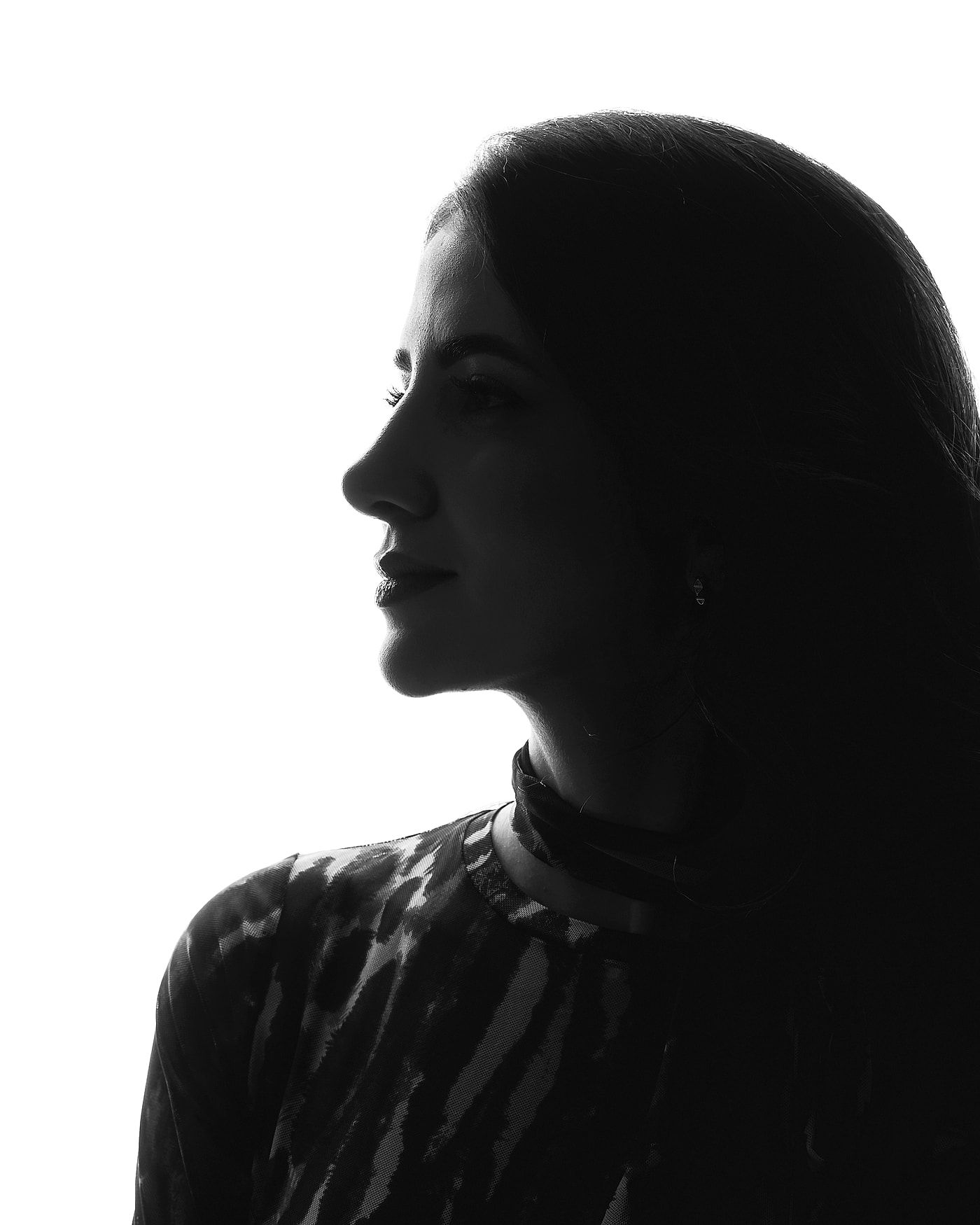 Perfil da Dra. Jéssica Curi contra a luz, em preto e branco